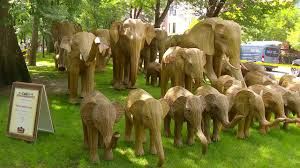 One hundred handcrafted elephant sculptures displayed on the lawn of the Commonwealth Avenue Mall in Boston.