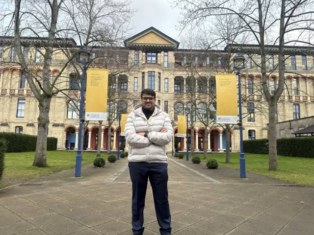 Aman Attra standing in front of the Cambridge Judge Business School gate after a tour of the campus.