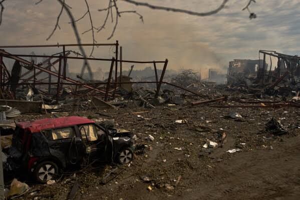 Debris and destroyed vehicles sit outside a warehouse in Myla following a Russian strike.