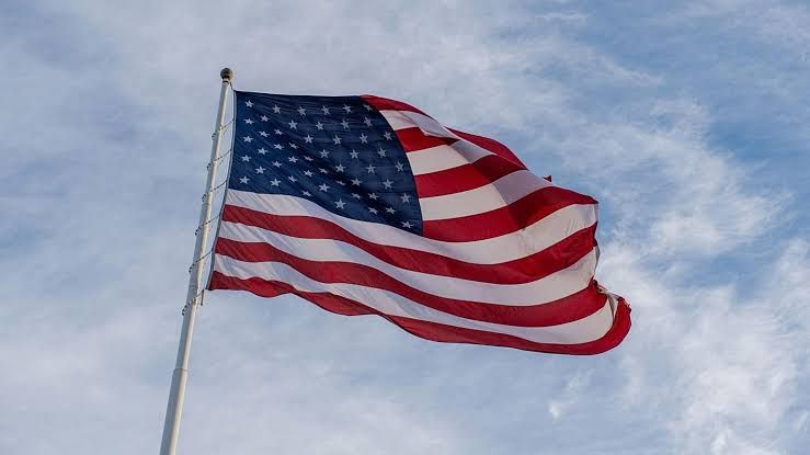 US flag flying in front of the Capitol building in Washington, representing the growing national debt.