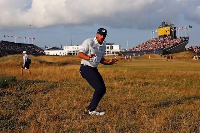 Bryson DeChambeau holding a golf club on a course at the 2026 Open Championship.
