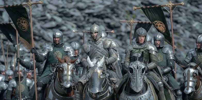 Freddie Fox as Gwayne Hightower wearing armor while standing on a battlefield in House of the Dragon.