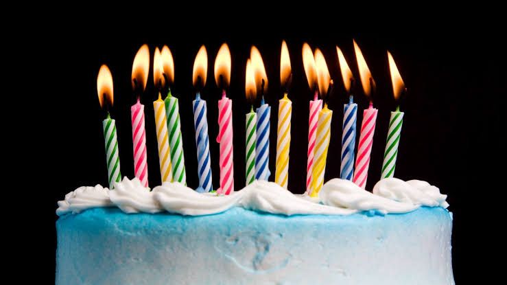A birthday cake with lit candles representing the financial milestone decisions for Social Security retirement age.