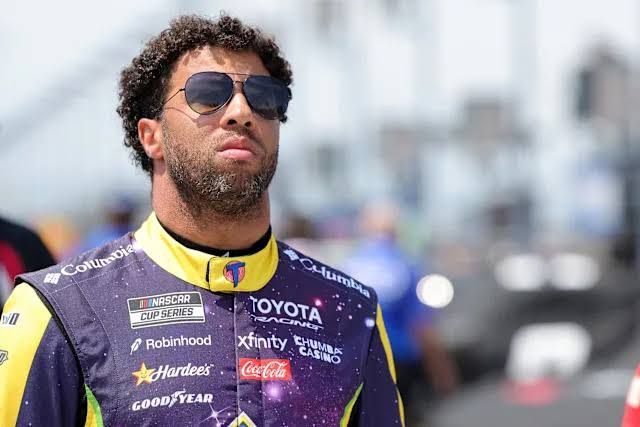 Bubba Wallace sits in his 23XI Racing car during a pit stop at a NASCAR Cup Series race.