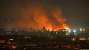 Fire plumes rise from damaged civilian infrastructure in Kyiv following a Russian ballistic missile strike at night.