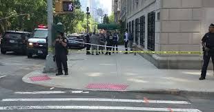 NYPD officers and emergency vehicles stationed outside an apartment building on Amsterdam Avenue after an arrest.
