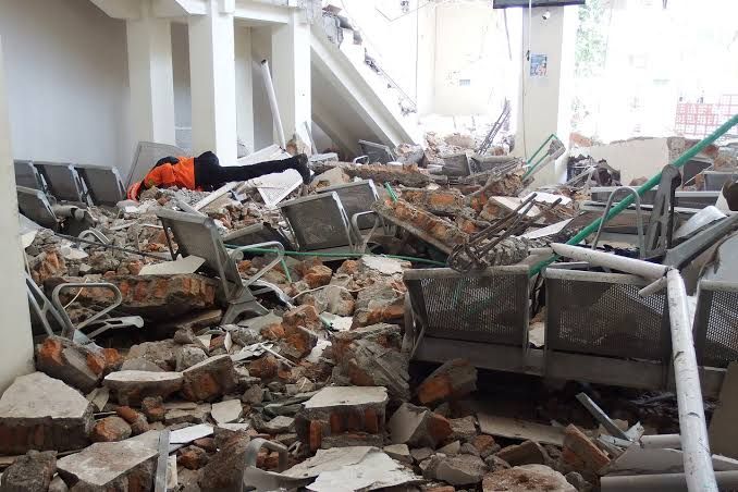 Rescue workers searching for survivors among the rubble of collapsed buildings in Maumere following a major earthquake.