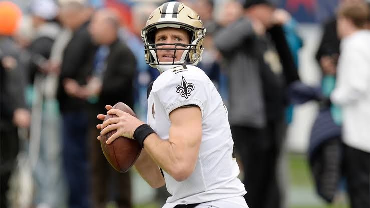 Quarterback Drew Brees stands on the field wearing his New Orleans Saints uniform during an NFL game.