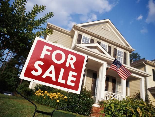 A stylized graphic showing a rising interest rate trend line superimposed over a residential suburban housing development.