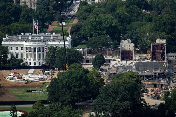 Construction scaffolding and equipment surrounding the partially built White House ballroom structure in Washington D.C.
