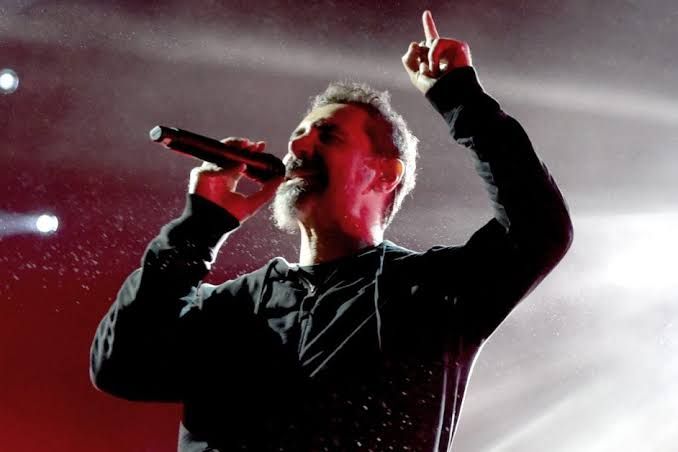 Serj Tankian performing on stage during a System of a Down concert event.