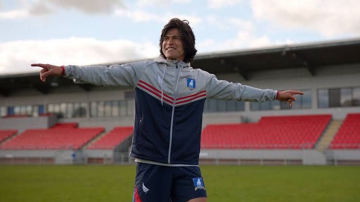 Maria Rojas smiling on the pitch during a tryout for the new AFC Richmond women's team in Ted Lasso.
