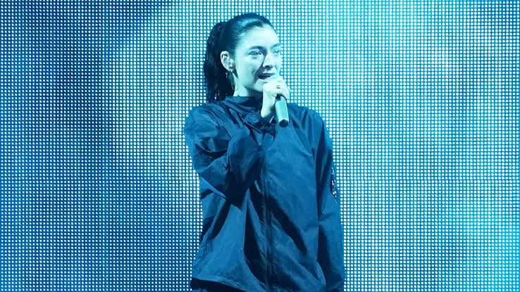 Lorde performing on stage during a concert tour.