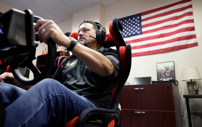 US Marine Corps veteran Jose Agurto concentrates while driving a race car simulator during a mental health study.