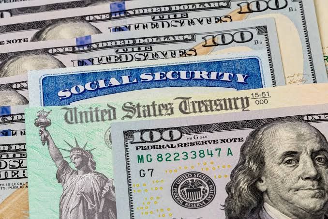A close-up of a Social Security check or benefit statement with a calculator in the background.