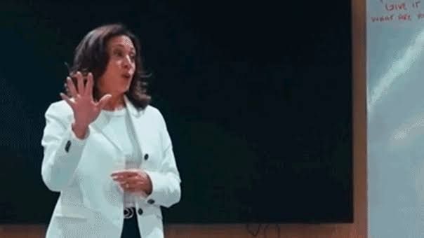 Kamala Harris standing on the court at a Los Angeles Sparks basketball game while addressing the players.