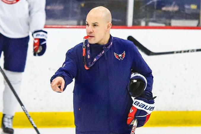 Head coach Spencer Carbery standing on the ice during a Washington Capitals practice session.