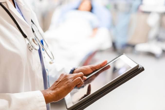 A close-up of a patient typing a message into an electronic health record portal on a laptop screen.