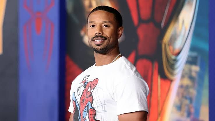 Michael B. Jordan wearing a suit at a film premiere in Los Angeles while discussing movie news.