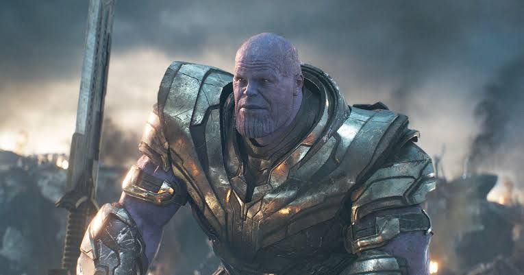 Thanos standing in a battle-worn landscape from the final act of Avengers: Endgame.