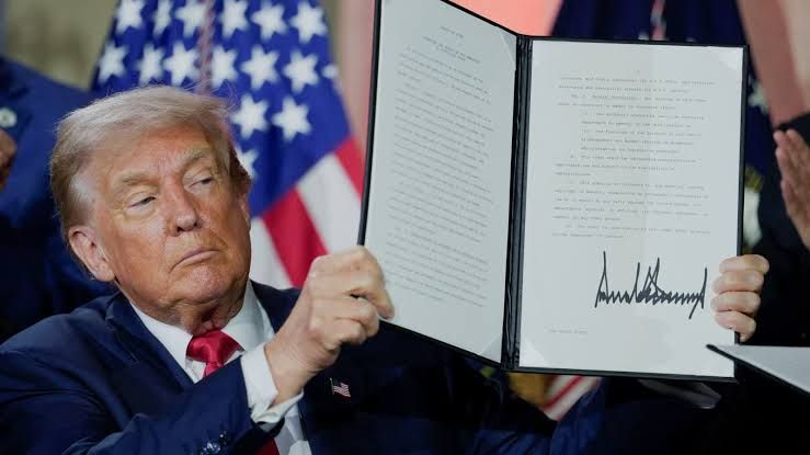 U.S. President Donald Trump holds an executive order related to artificial intelligence during a summit in Washington D.C.