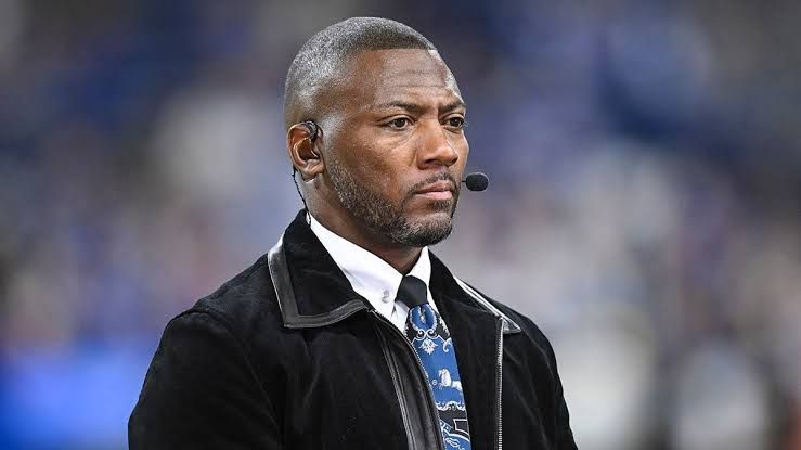 NFL analyst Ryan Clark stands on the field at a stadium during a pre-game broadcast for ESPN.