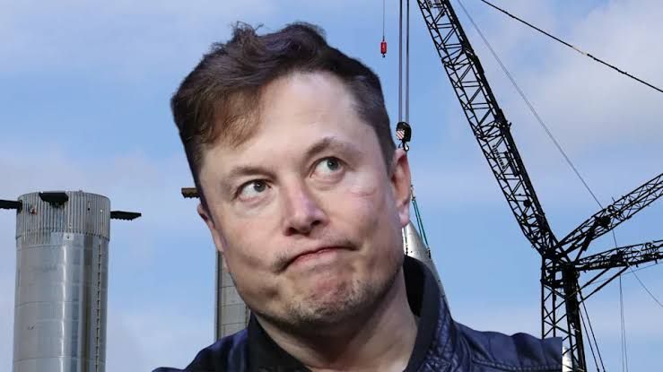 Elon Musk standing in front of a SpaceX rocket during a press event regarding company growth and future missions.