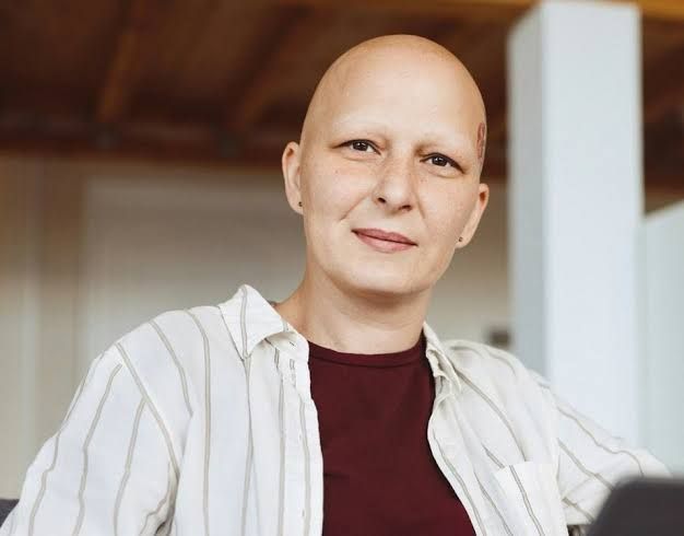 Close up of a person applying treatment to their scalp in a medical setting, representing new research in hair loss.