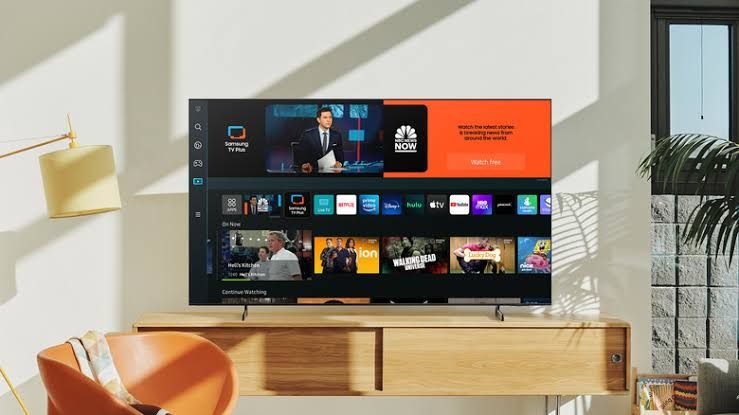 Samsung smart TV displaying its home screen interface with various app icons visible.