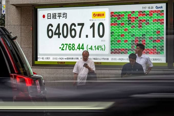 A stock market trading floor display showing a decline in major indices including the Nasdaq and S&P 500.