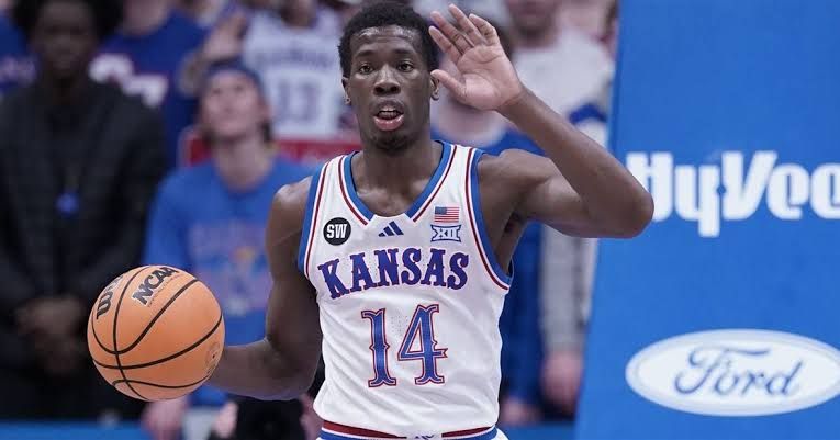 Melvin Council Jr. playing basketball in a Kansas Jayhawks uniform during a game.