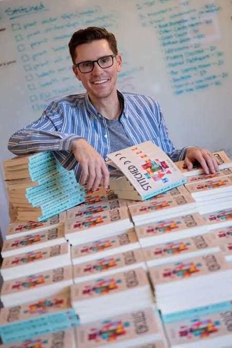 Eli McCann signing copies of his new novel Stitched at a book launch event in Utah.