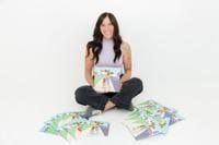 Author Savannah Adams holding her children's book The Biz Kids: A Sticky Situation.
