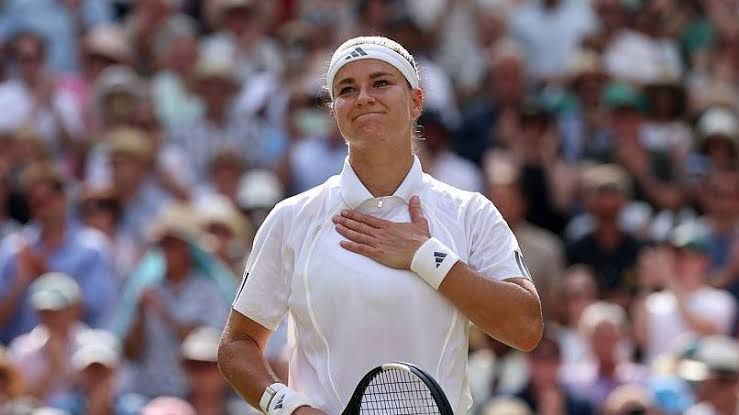 Karolina Muchova waves to the spectators during the 2026 Wimbledon tournament.