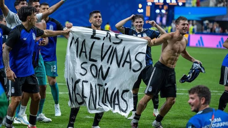 Argentine players holding a banner claiming sovereignty over the Falkland Islands after defeating England in the World Cup.