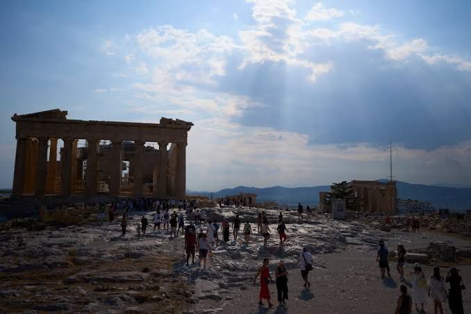 Tourists walking on a pedestrian street near the Acropolis entrance in Athens following a stabbing attack.