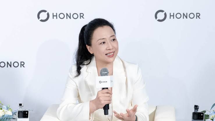 Honor smartphone displaying an AI-driven interface on the screen in a modern technical environment.