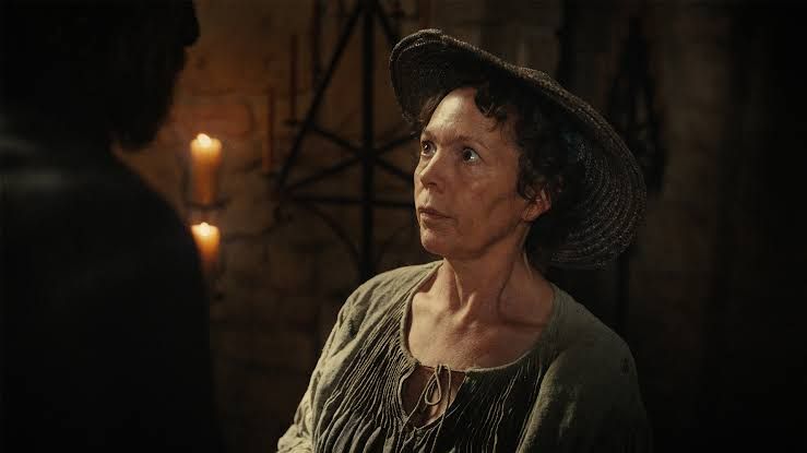 Olivia Colman standing alongside a wicker-constructed figure played by Alexander Skarsgard in the film Wicker.