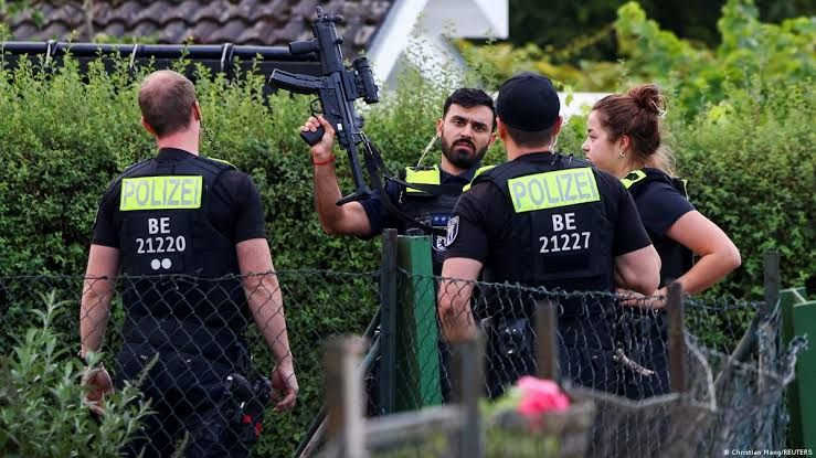 Police tape surrounds a garden area in Spandau where officers neutralized the suspect in the Berlin Pride attack.