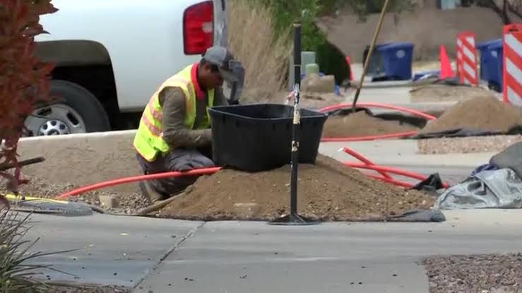 Crews digging trenches for fiber optic cables in an Albuquerque residential neighborhood.
