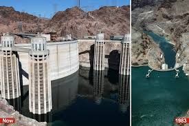 Hoover Dam intake towers surrounded by low water levels revealing dry rocky terrain in Lake Mead.