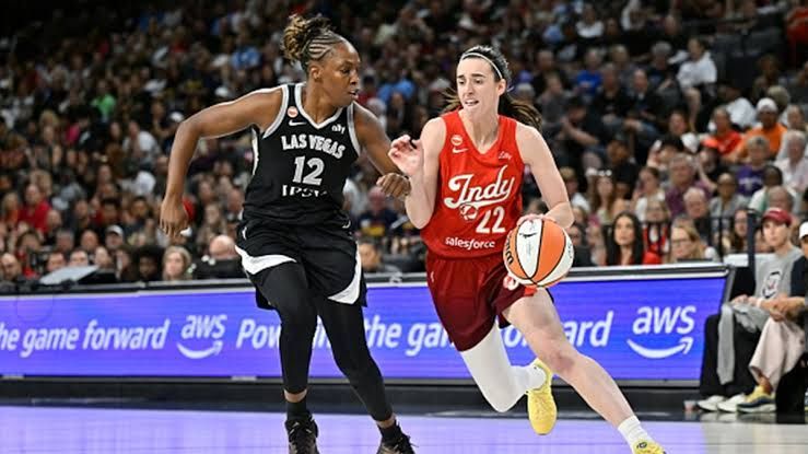 Indiana Fever guard Caitlin Clark moves toward the basket as Las Vegas Aces defender Chelsea Gray attempts to stop her.