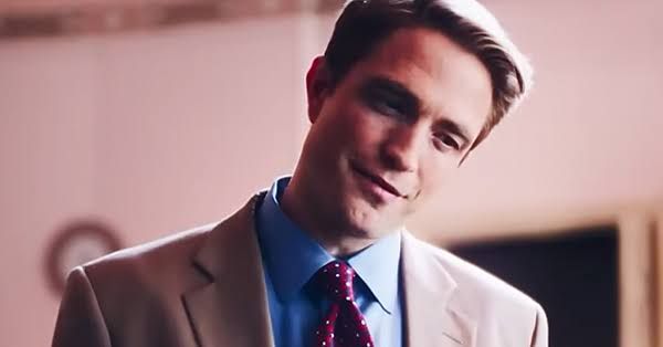Robert Pattinson staring intensely as Chris Hansen in the film Primetime, set against a dark and moody studio background.