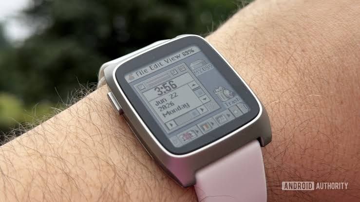 Pebble Time 2 watch displayed on a wrist during a rain shower to show its outdoor display readability.