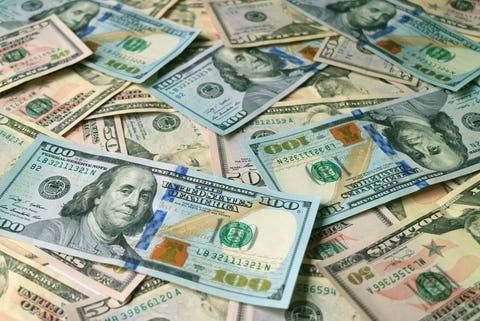 A close-up of a large stack of United States dollar bills representing wealth and business.
