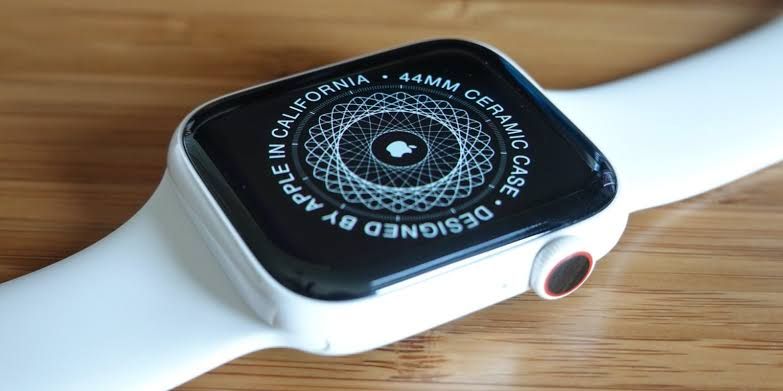 White ceramic Apple Watch Series 5 on a wrist with a matching band in a bright indoor setting.