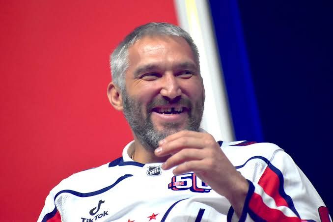 Alex Ovechkin laughing during a public event in his Washington Capitals gear.