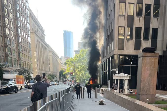 Flames and black smoke rising from the steps of the 26 Federal Plaza building in Manhattan after a security incident.