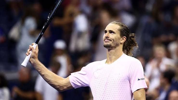 Alexander Zverev raises his racquet to the crowd at Arthur Ashe Stadium after winning his quarter-final match.