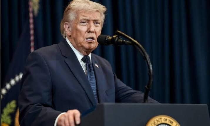 President Donald Trump speaking at a podium regarding the positive August employment report.